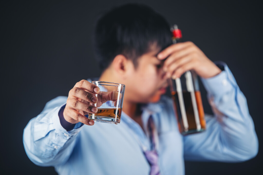homem segurando bebida alcoólica