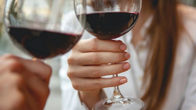 Mulheres com taças de vinho nas mãos e bebendo, possivelmente são vítimas de alcoolismo feminino